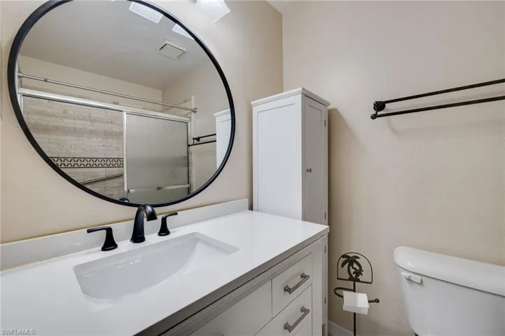 Bathroom with vanity and tiled shower