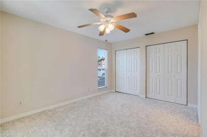 Unfurnished bedroom with multiple closets, a textured ceiling, and a ceiling fan