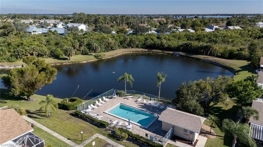 Drone / aerial view of a tree filled landscape and a large body of water