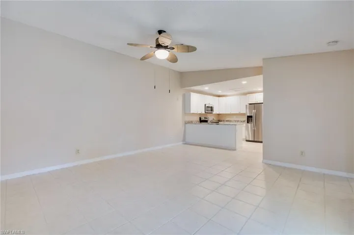 Unfurnished living room with a ceiling fan, recessed lighting, light tile patterned floors, and lofted ceiling