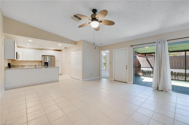 Unfurnished living room with ceiling fan, light tile patterned floors, a textured ceiling, recessed lighting, and vaulted ceiling