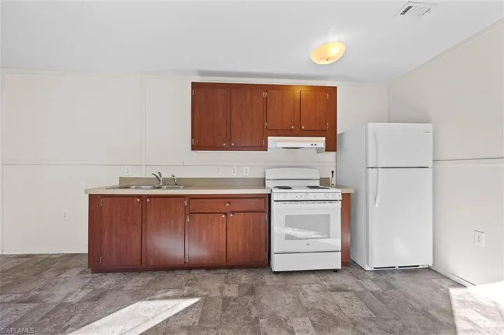 Kitchen with white appliances and sink