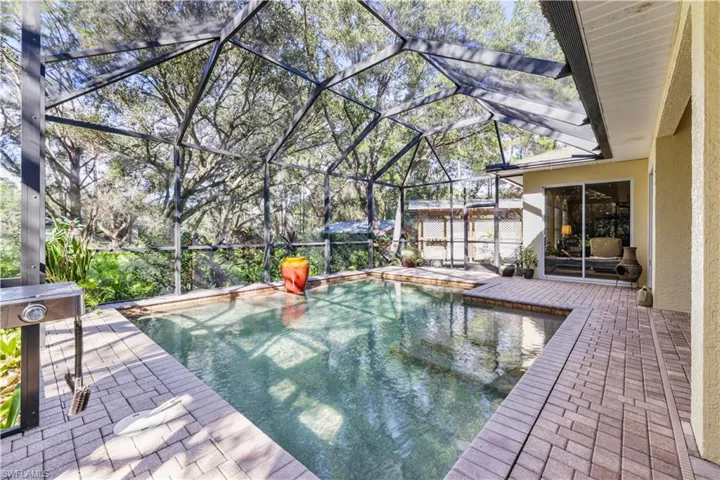 View of swimming pool with glass enclosure, a patio, and a sunroom