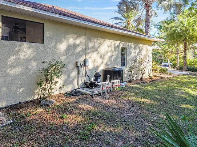 View of side of property featuring stucco siding and a lawn