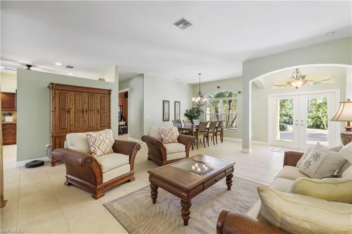 Living room featuring light tile patterned flooring, french doors, a chandelier, and recessed lighting