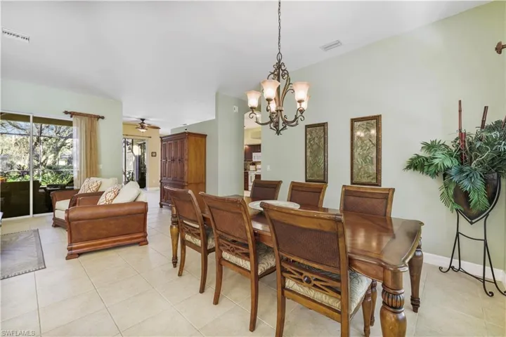 Dining space featuring light tile patterned flooring, a chandelier, and ceiling fan