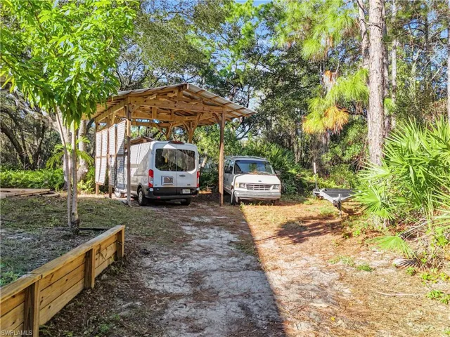 View of yard featuring a detached carport and driveway