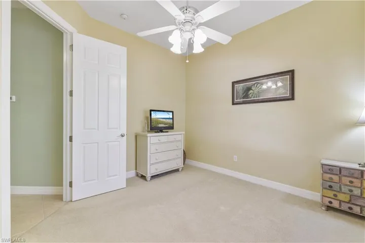 Unfurnished bedroom with light carpet and a ceiling fan