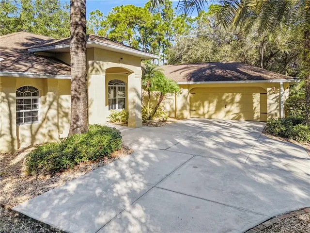View of front of house with stucco siding and concrete driveway