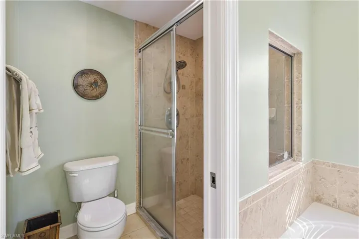 Full bath with a stall shower, a garden tub, and tile patterned floors