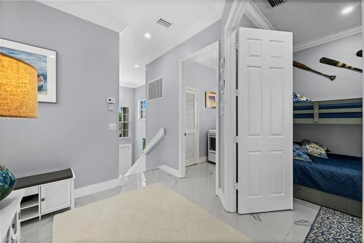 Hall with an upstairs landing, recessed lighting, light marble finish floors, ornamental molding, and washer / clothes dryer