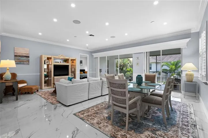 Dining room with crown molding, light marble finish floors, and recessed lighting
