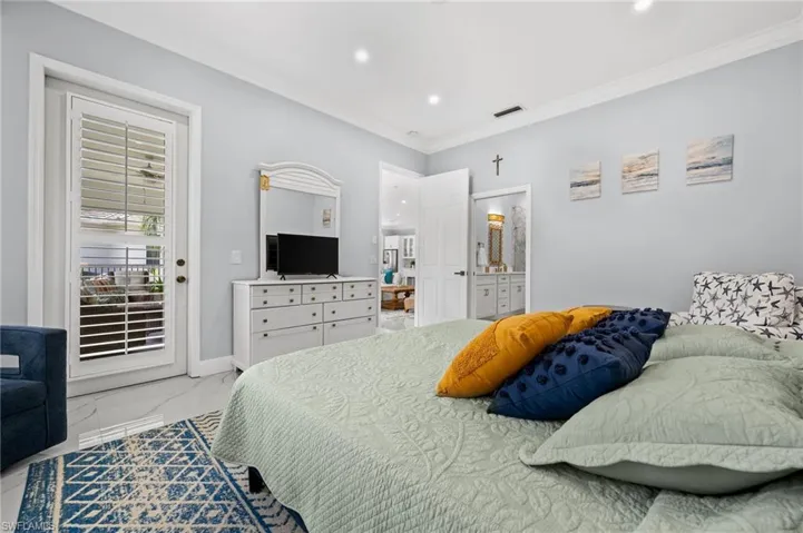 Bedroom with access to exterior, recessed lighting, crown molding, connected bathroom, and light marble finish flooring