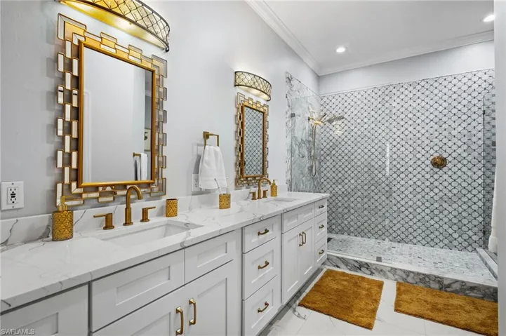 Bathroom with a shower stall, double vanity, ornamental molding, recessed lighting, and light tile patterned floors