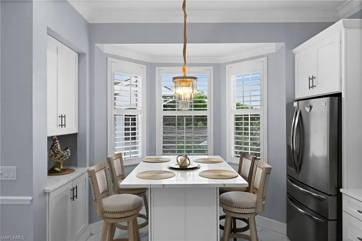 Dining area with healthy amount of natural light, ornamental molding, and light tile patterned flooring