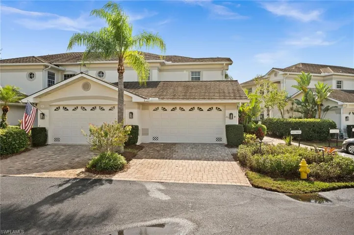 View of front facade featuring decorative driveway, a garage, and stucco siding