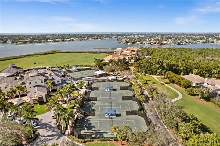 Aerial view of residential area featuring a nearby body of water and a golf course