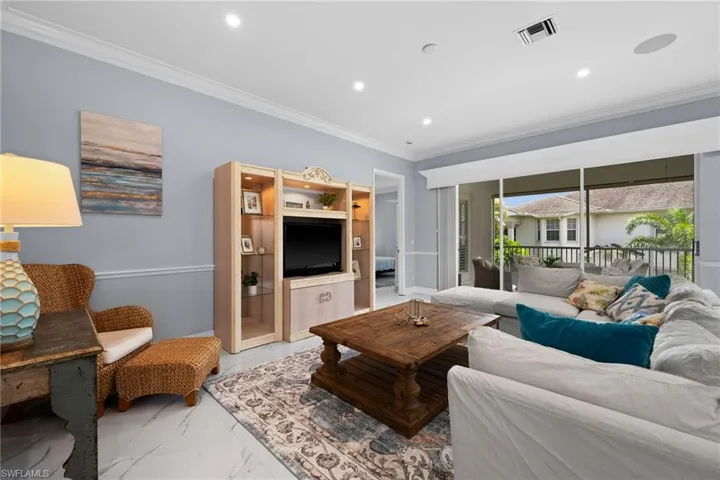 Living room featuring ornamental molding, marble finish flooring, and recessed lighting