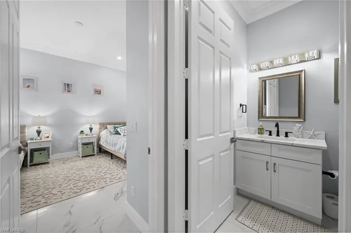Bathroom with crown molding, vanity, light marble finish flooring, ensuite bath, and recessed lighting
