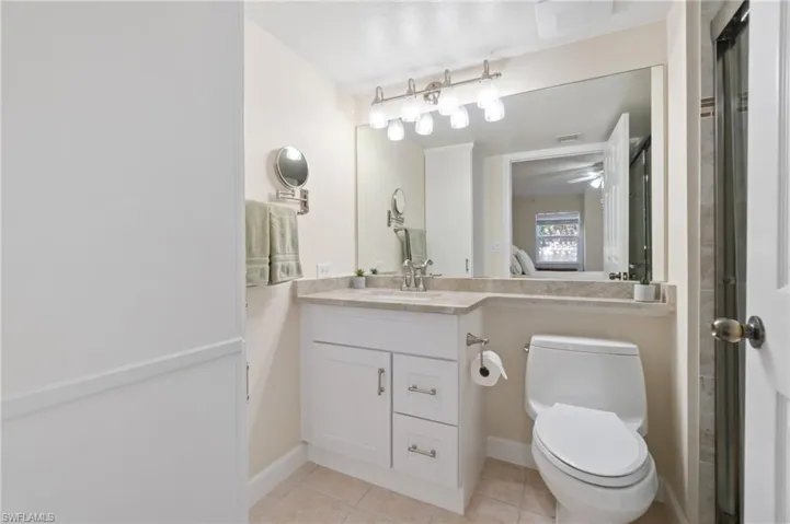 Full bathroom with tile patterned flooring, baseboards, vanity, and toilet