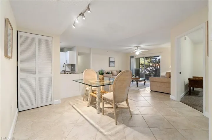 Dining room with light tile patterned floors, a ceiling fan, and baseboards