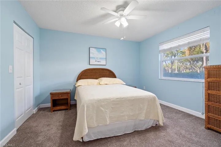 Bedroom with baseboards, a ceiling fan, carpet, a textured ceiling, and a closet