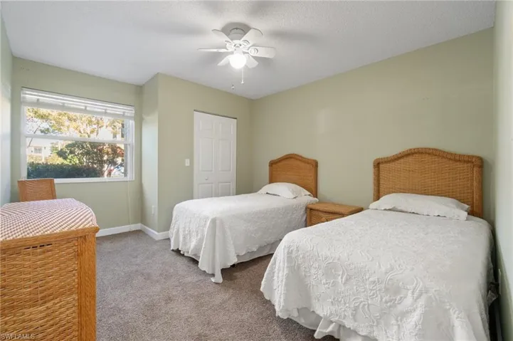 Carpeted bedroom featuring a ceiling fan, a closet, a textured ceiling, and baseboards