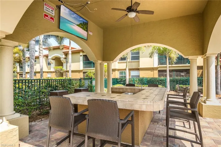 View of patio / terrace with ceiling fan, fence, and outdoor dry bar