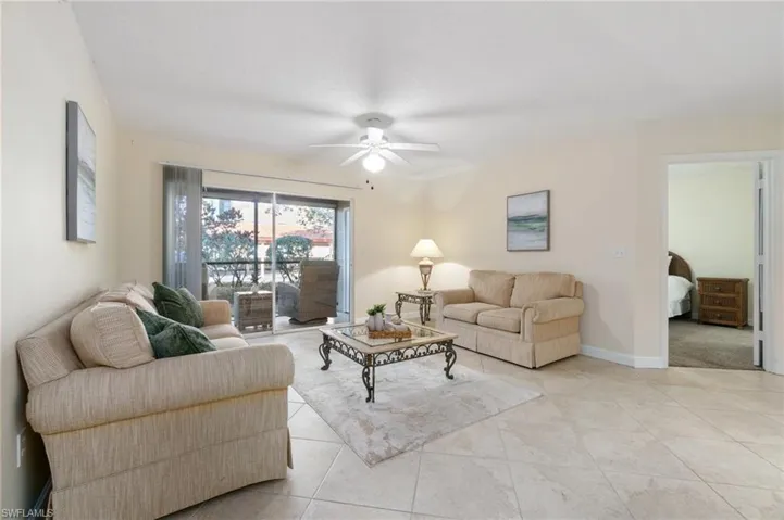Living area featuring light tile patterned floors, baseboards, and a ceiling fan