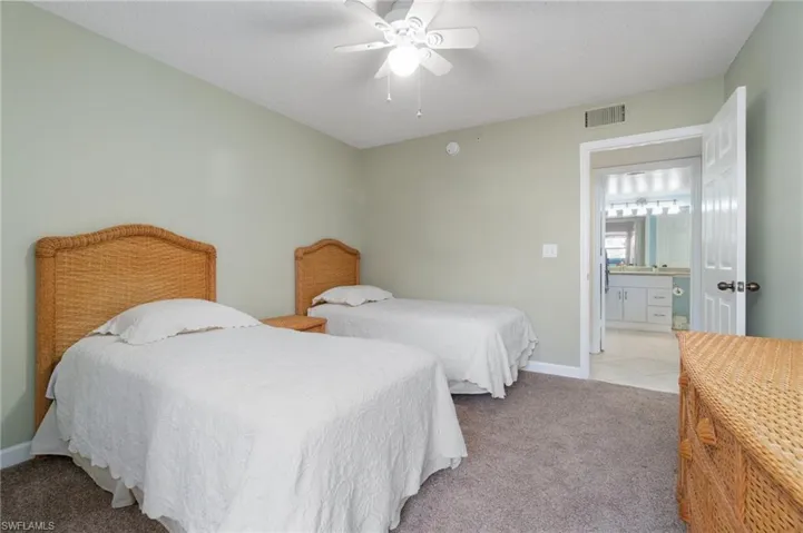 Bedroom with light carpet, ceiling fan, visible vents, and baseboards