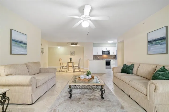 Living area featuring light tile patterned floors and a ceiling fan