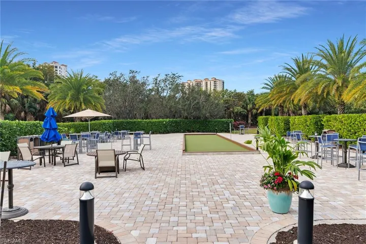 View of property's community featuring a bocce ball area, a patio, and outdoor dining area