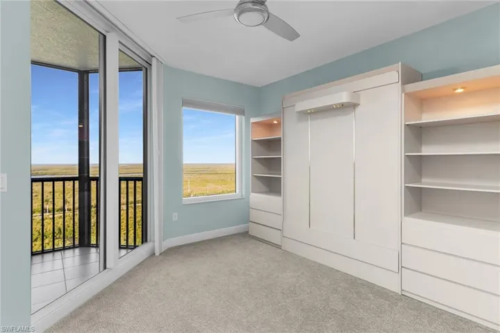 Unfurnished bedroom with light colored carpet and ceiling fan
