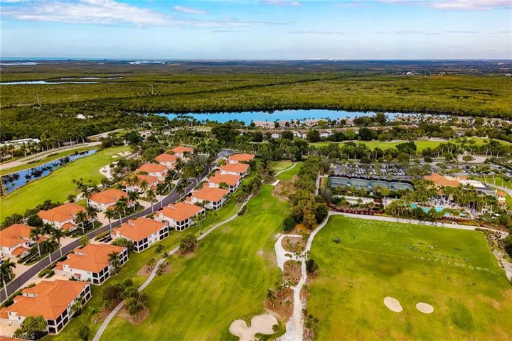 Aerial perspective of suburban area featuring a nearby body of water and a golf club