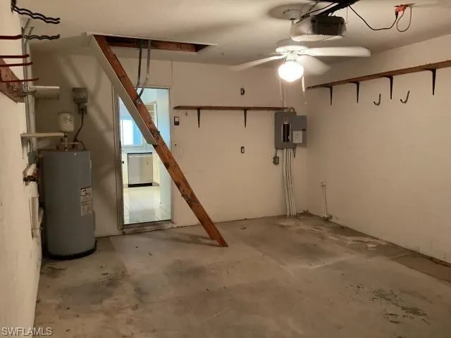 Basement featuring water heater, electric panel, ceiling fan, and a garage