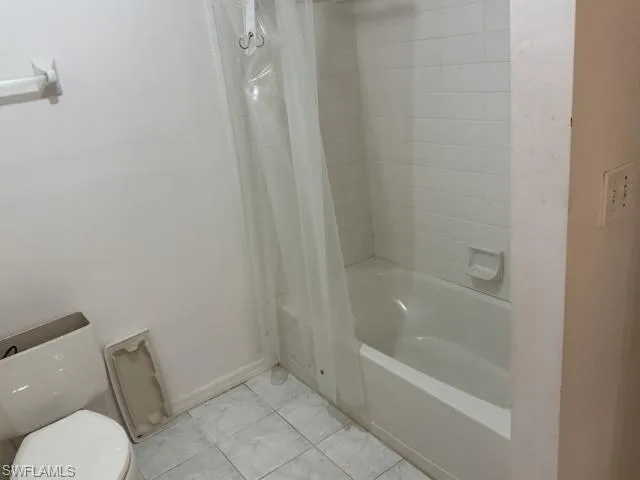 Full bathroom featuring shower / bath combo and light tile patterned floors