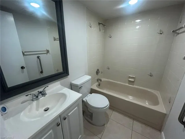 Full bath with tile patterned flooring, vanity, shower / bath combination, and toilet