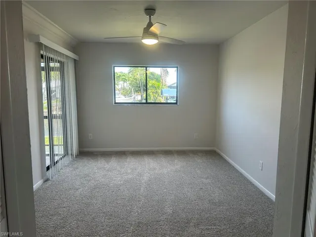 Empty room featuring baseboards, carpet flooring, ceiling fan, and a healthy amount of sunlight