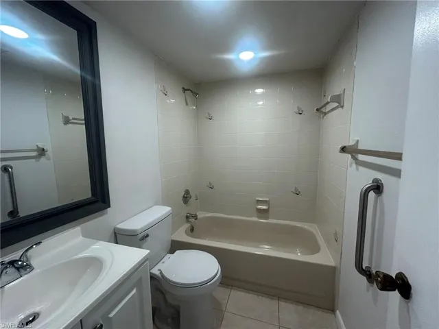 Bathroom featuring shower / bathing tub combination, toilet, tile patterned flooring, and vanity