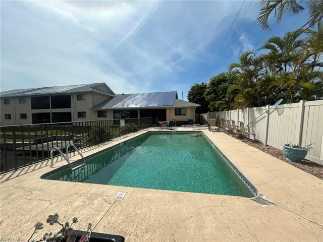 Community pool with a fenced backyard and a patio area