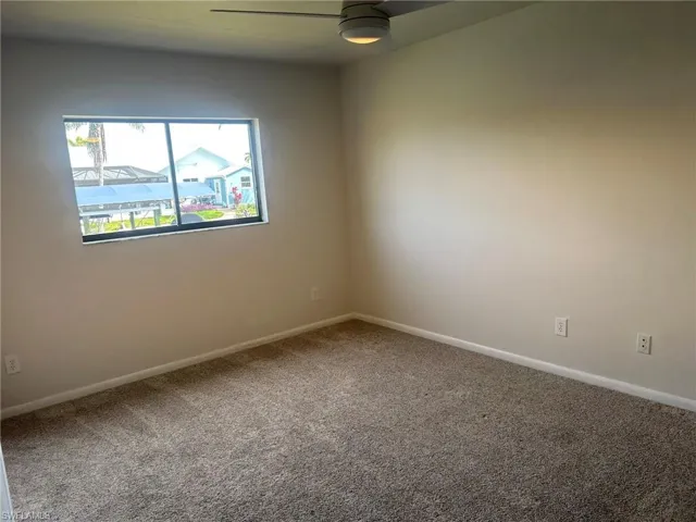 Spare room featuring baseboards, carpet flooring, and a ceiling fan