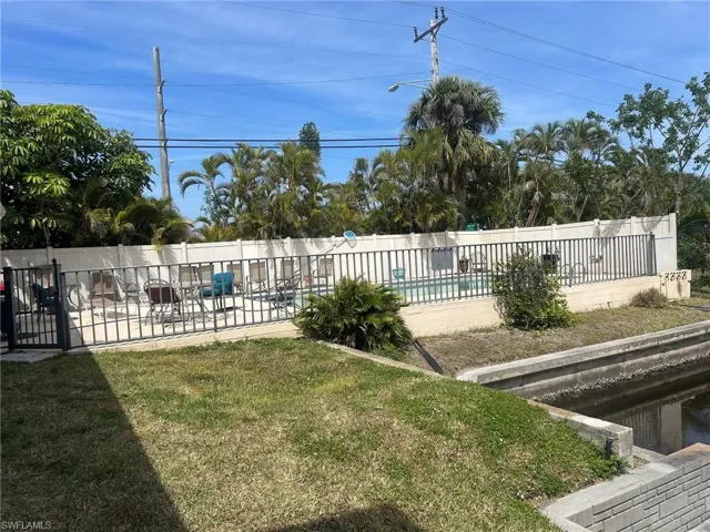 View of yard featuring a patio area, a community pool, and fence