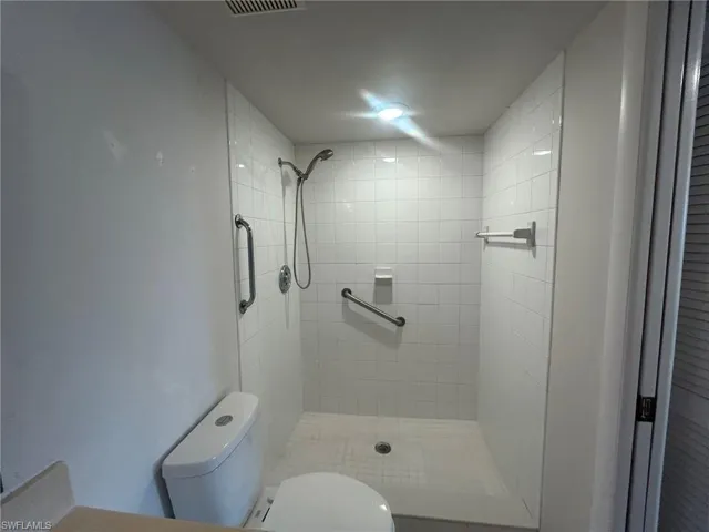 Bathroom featuring toilet and tiled shower