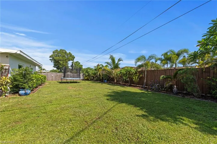 Expansive lawn area with a wood privacy fence, mature trees, and established landscaping