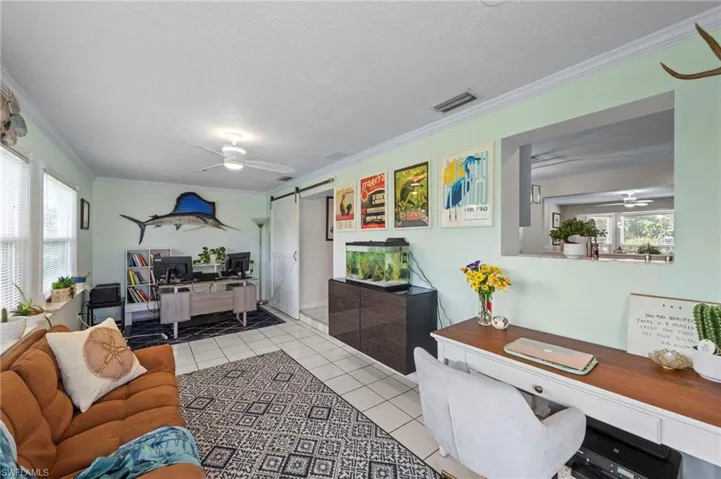 Recessed lighting, ceiling fan, white tile flooring, pass-through opening, and a sliding barn door