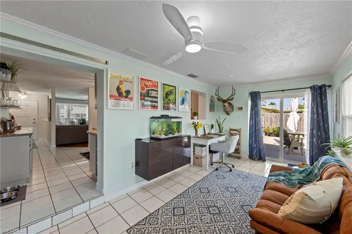 Recessed lighting and a modern ceiling fan illuminate the living area