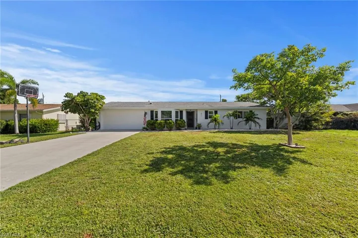 Single-story residence featuring a white exterior, attached two-car garage, and a concrete driveway