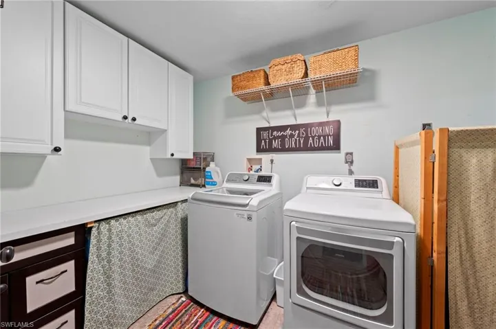 White upper cabinetry, white countertops, built-in shelving, and a dark wood-finish lower cabinet