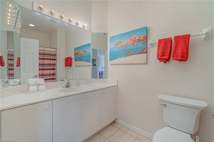 Guest bathroom featuring tile patterned flooring, vanity, and bath/shower tub