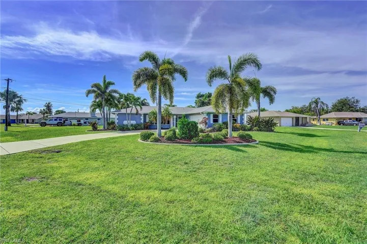 Single story home with concrete driveway and a front yard